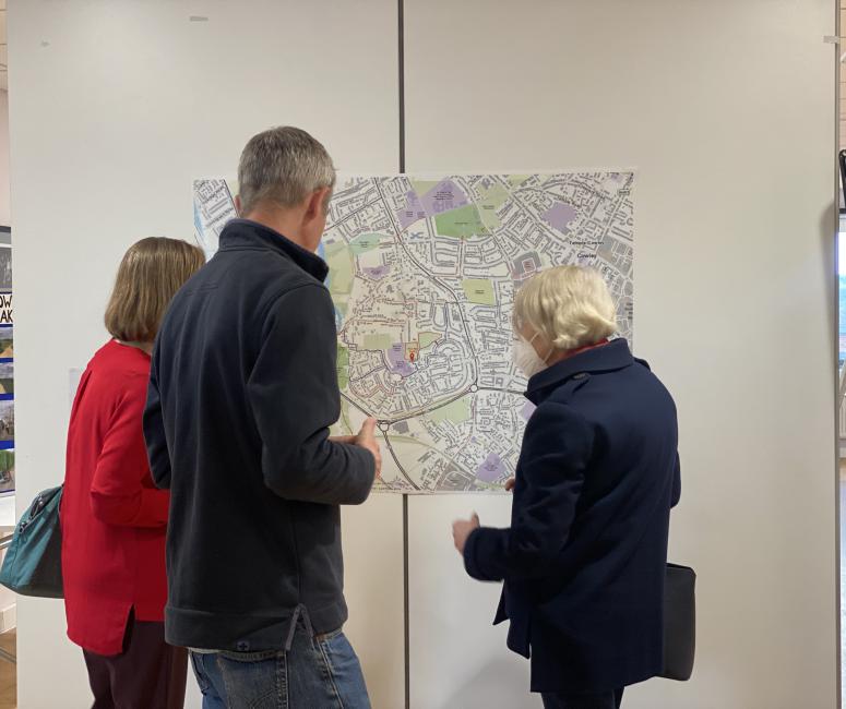 Three people standing in front a map of Rose Hill